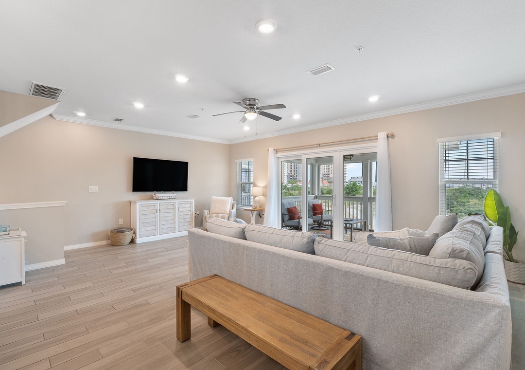 Saltwater & Sunsets- Relax in your spacious living room, where plush seating, soft neutral tones, and natural light create a welcoming space to unwind after a day of adventure.