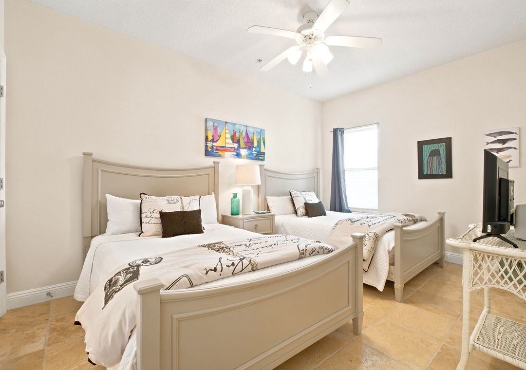 Unwind in your coastal-inspired twin bedroom with soothing beach-themed decor, natural light, and a gentle ceiling fan keeping you cool throughout your stay.