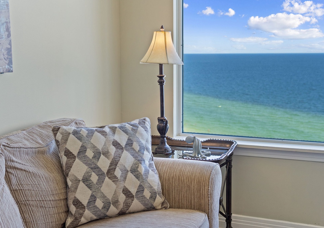 Sink into the comfort of this cozy corner and let your gaze drift across the endless ocean horizon stretching beyond your window.