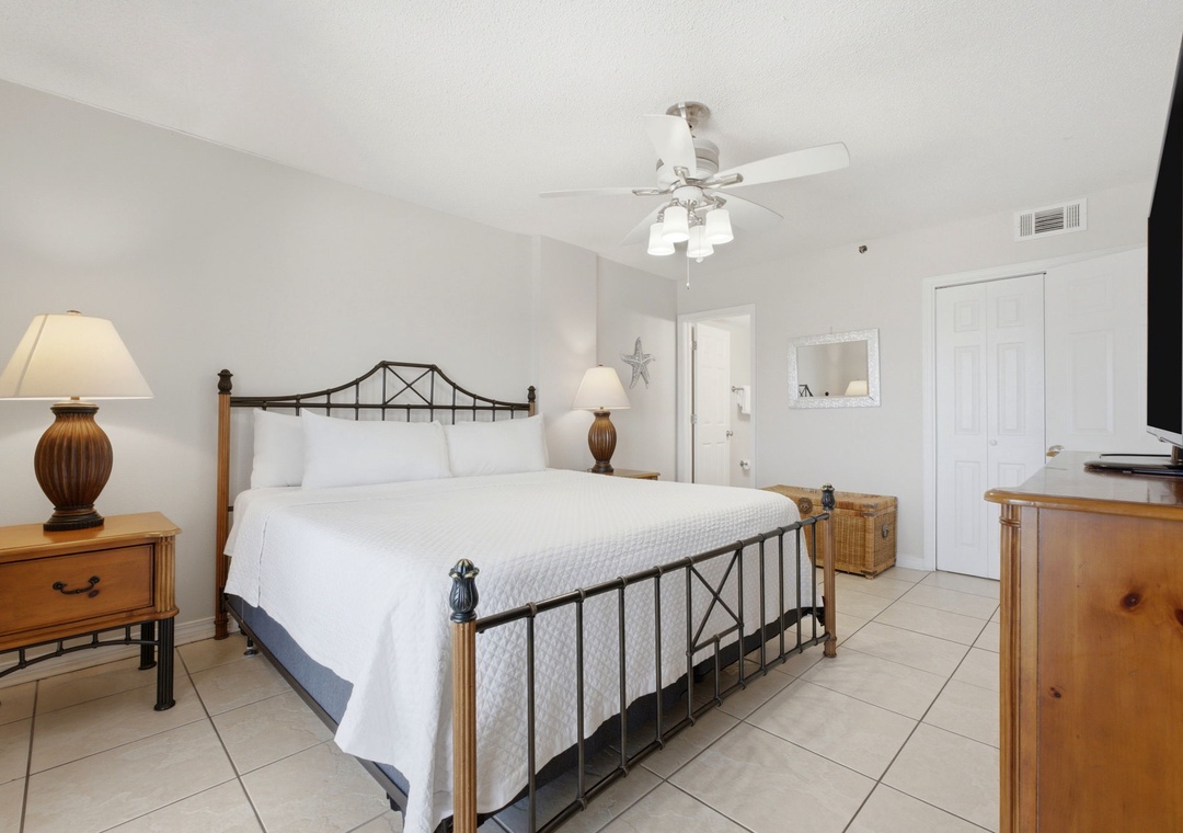 Ocean Breeze E702- Your bright, serene bedroom awaits with crisp linens and coastal charm. Sink into plush bedding, enjoy the ceiling fan's gentle breeze, and unwind with entertainment or the peaceful ambiance of your beach getaway.
