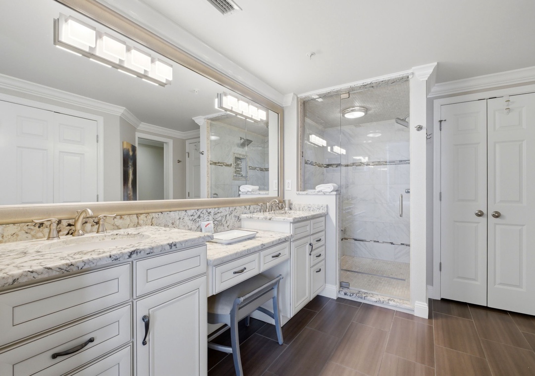 Elegant marble countertops and a spacious walk-in shower create a spa-like retreat. The built-in vanity nook offers a perfect spot for your morning routine.