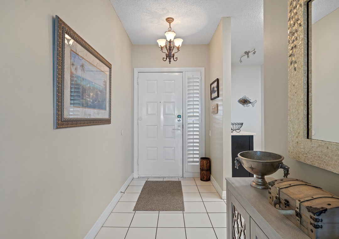 Beach Colony T15B- Step inside to find a bright, welcoming entryway with warm lighting and classic tile floors greeting you at the door.