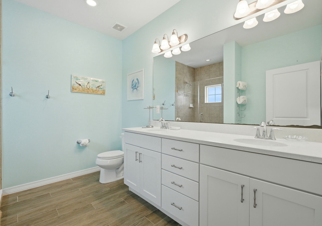 Step into your bright coastal bathroom with dual vanities, a soothing spa palette, and a spacious walk-in shower—your personal retreat after beach adventures.