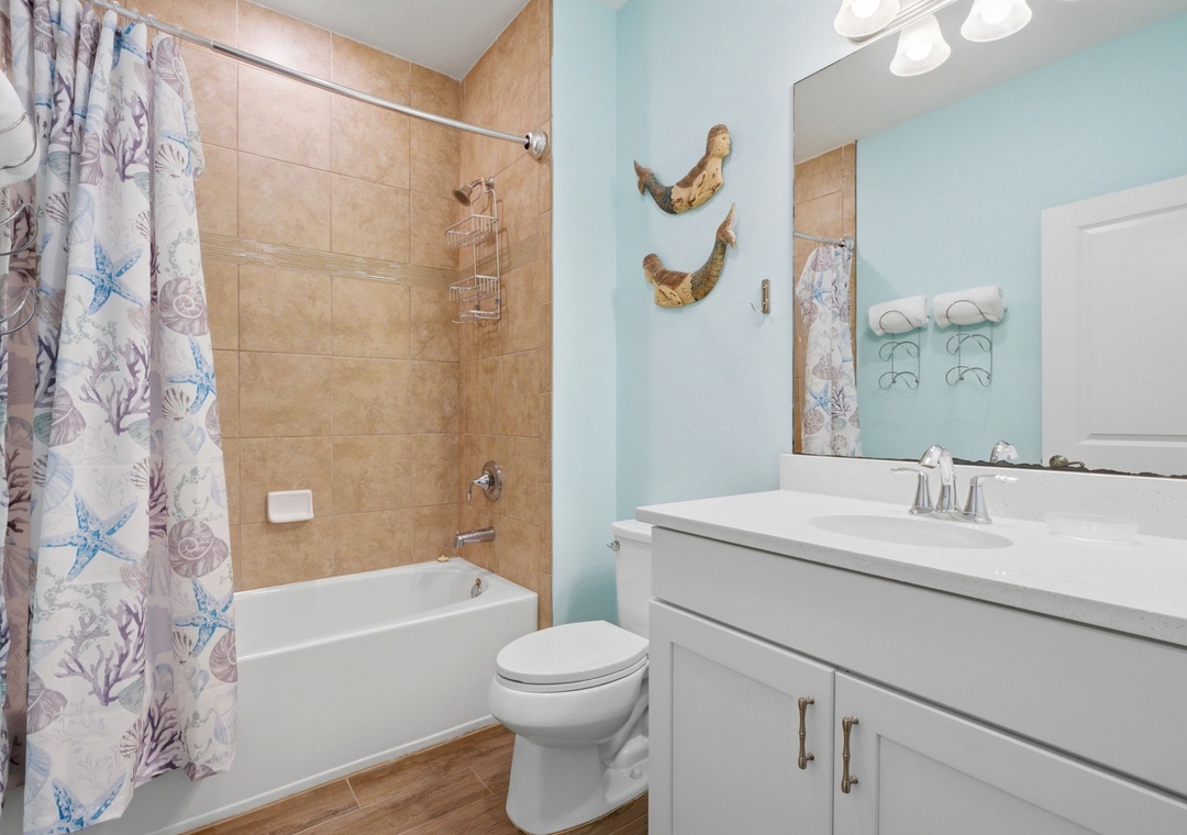 Refresh after a day of adventure in this coastal-themed bathroom with a tub-shower combo, beach-inspired décor, and all the essentials you need to feel at home.