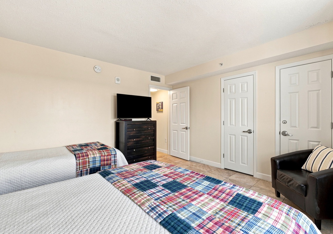 Sandy Key 411- Settle into your spacious room with two cozy beds dressed in cheerful plaid throws, plus a leather reading chair and all your entertainment needs close at hand.