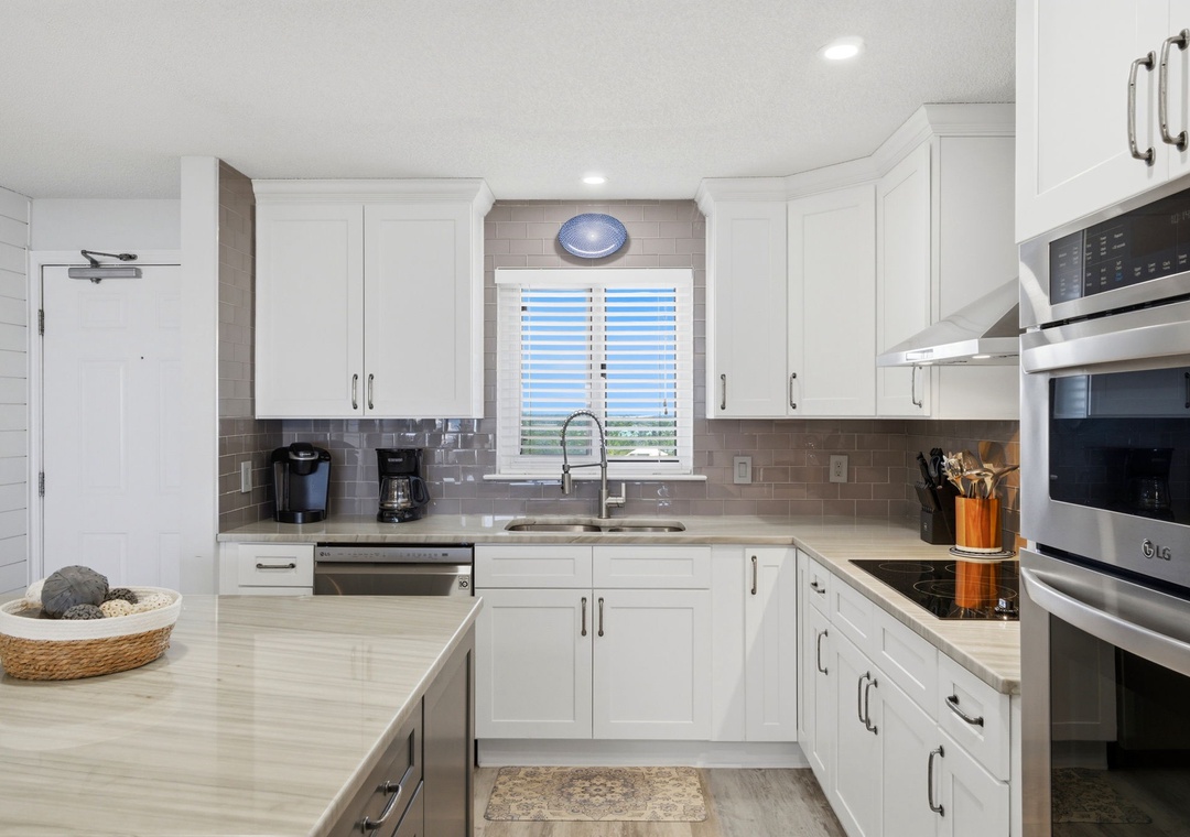 Your spacious kitchen features sleek white cabinetry, modern appliances, and plenty of counter space to prepare delicious meals during your stay.
