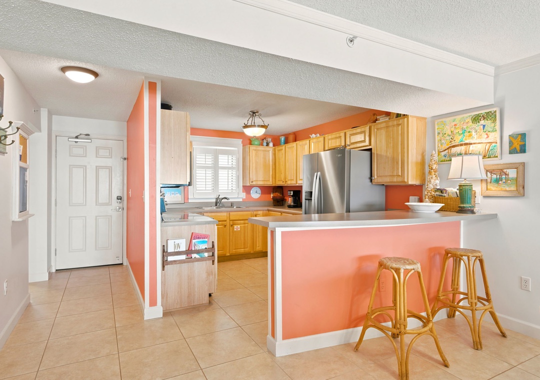 Sandy Key 338- Gather around this cheerful kitchen with warm coral accents, modern stainless appliances, and a welcoming breakfast bar where you can enjoy your morning coffee in tropical style.