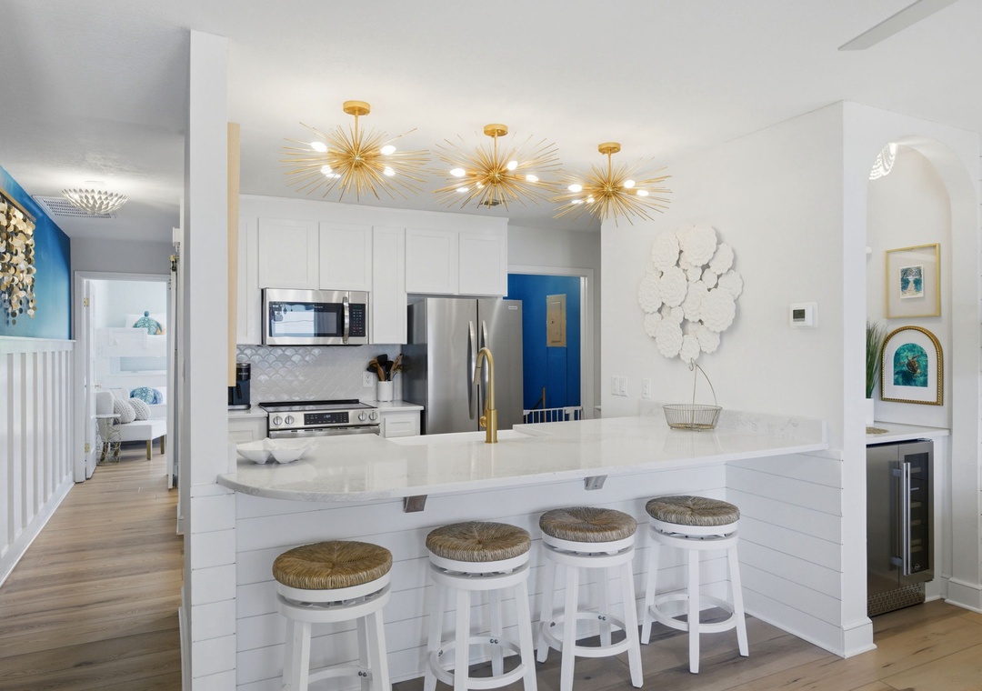 North Lost Key Landing B2- Prepare your favorite meals in this stunning chef's kitchen, featuring gleaming marble countertops, modern appliances, and stylish gold starburst lighting that creates the perfect ambiance for cooking and entertaining.