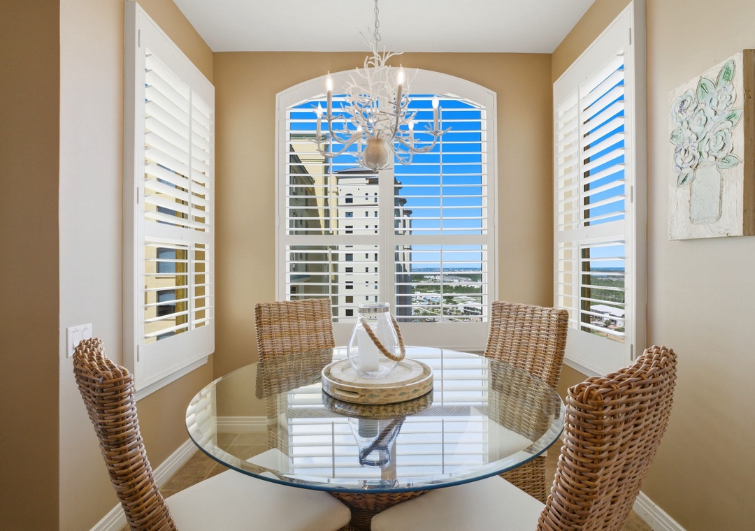Beach Colony T PH1D- Enjoy meals in this sunny dining nook with stunning coastal views. The elegant chandelier and woven chairs create a relaxed, beachy atmosphere perfect for your morning coffee or evening gatherings.