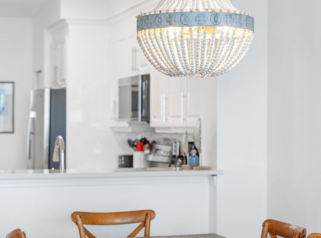 Beach Colony T14B- Gather around the handsome dining table beneath a statement chandelier, with your bright, open kitchen just steps away—perfect for easy entertaining and memorable meals.