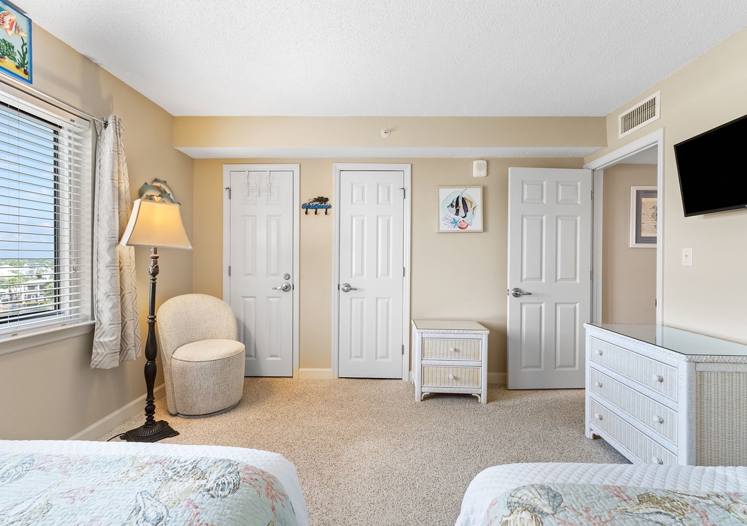 Sandy Key 628- Your peaceful bedroom features coastal decor, plush carpeting, and soft natural light—a restful retreat after sun-filled days. Unpack in the white wicker dresser and settle into the calm, beachy vibe.
