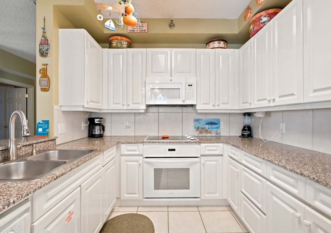 Beach Colony W13A- Your fully equipped kitchen invites you to prepare favorite meals with ample counter space, modern appliances, and a cheerful, homey feel that welcomes gatherings.