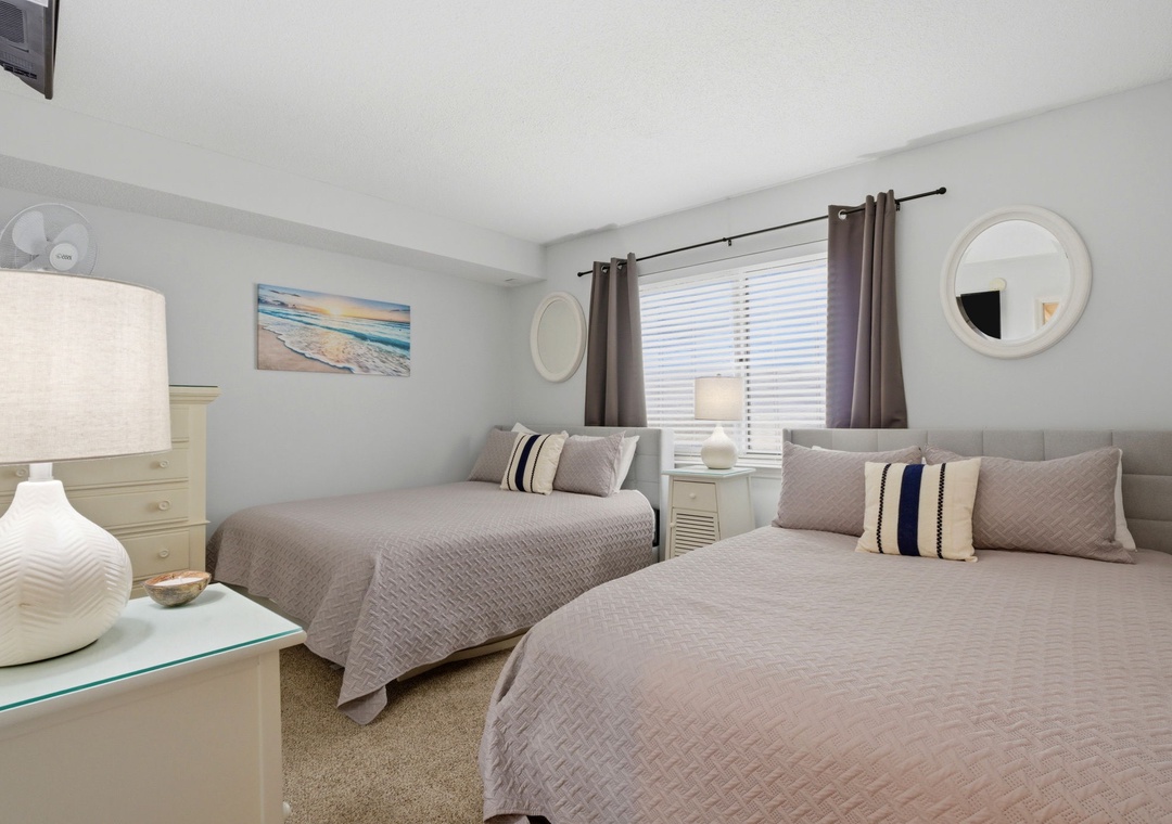 Your restful bedroom features two cozy beds dressed in soft linens, gentle natural light, and calming coastal touches that invite peaceful sleep and morning relaxation.
