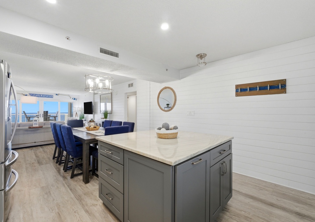 A sleek kitchen island awaits your culinary creations, while coastal views through the open living area remind you why you chose this seaside escape.