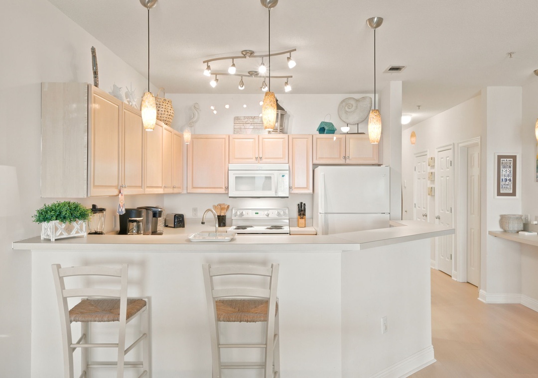 Picture yourself cooking in this bright, fully equipped kitchen with spacious counters, modern appliances, and a welcoming breakfast bar where you can share morning coffee.