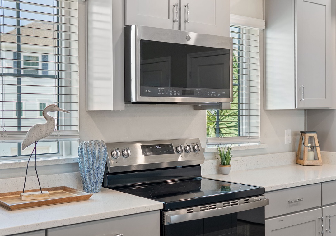 Saltwater & Sunsets- Your fully equipped kitchen features modern stainless steel appliances and bright natural light streaming through plantation shutters, making meal prep a pleasure during your stay.