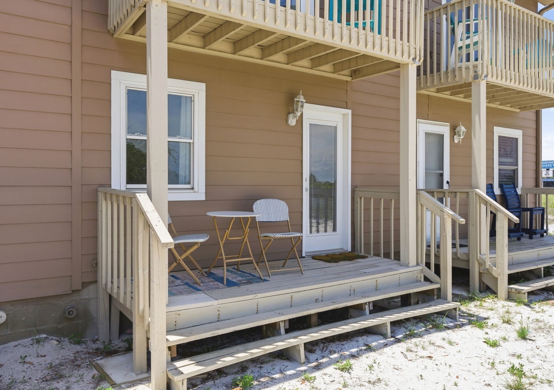 North Lost Key Landing B2- A sandy lot frames the property entrance, featuring elevated decks with seating and multi-level balconies with views of the surrounding area.