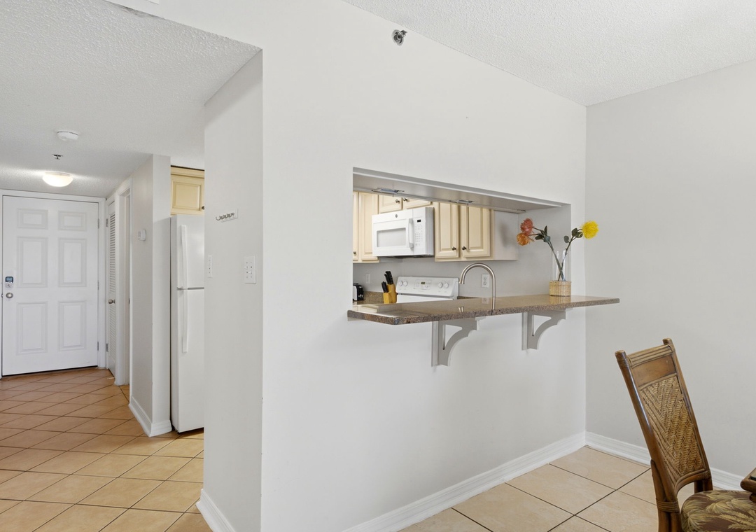 Ocean Breeze E702- Your open kitchen welcomes you with warm light wood cabinetry, granite countertops, and a breakfast bar perfect for morning coffee or casual meals together.