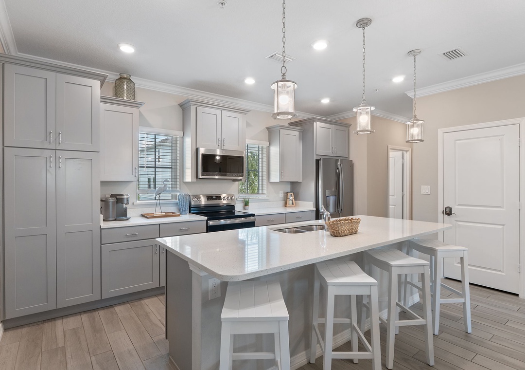 Saltwater & Sunsets- Step into this bright, airy kitchen where you'll find everything you need to create memorable meals. The spacious island invites you to gather with loved ones while elegant pendant lights cast a warm glow overhead.