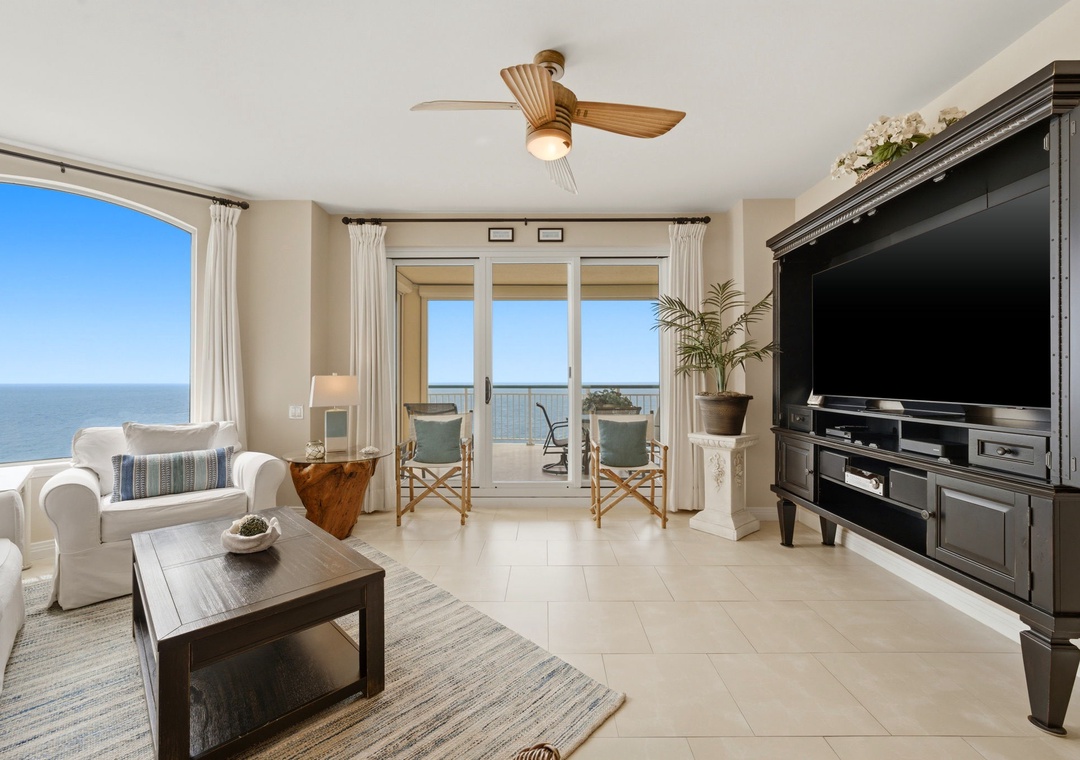Beach Colony Tower PH1B -Unwind in your bright coastal living room with stunning sea views, balcony access, and a large entertainment center for your favorite shows and movies.