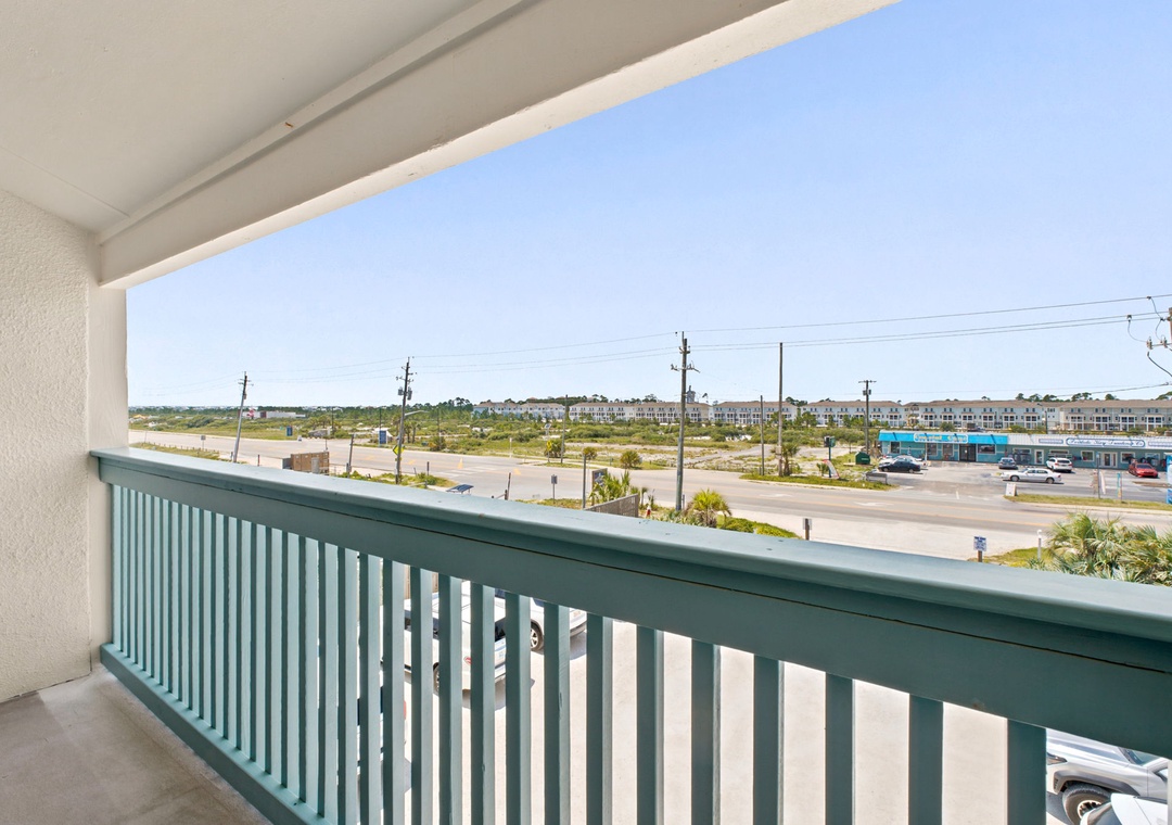 Gulfside Villas 2B- Street-level view from the balcony showcasing an open street and developing neighborhood in the surrounding area.