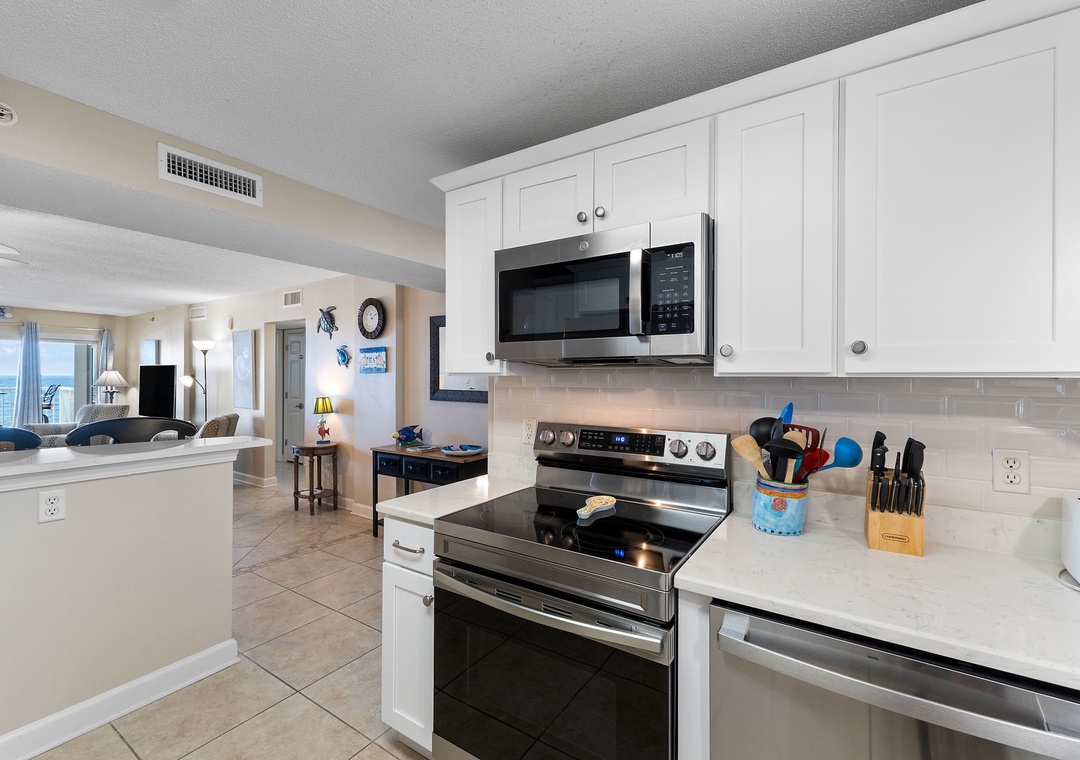 Sandy Key 628- Your fully equipped kitchen makes meal prep a breeze, with modern appliances and bright coastal views flowing through the open living space beyond.