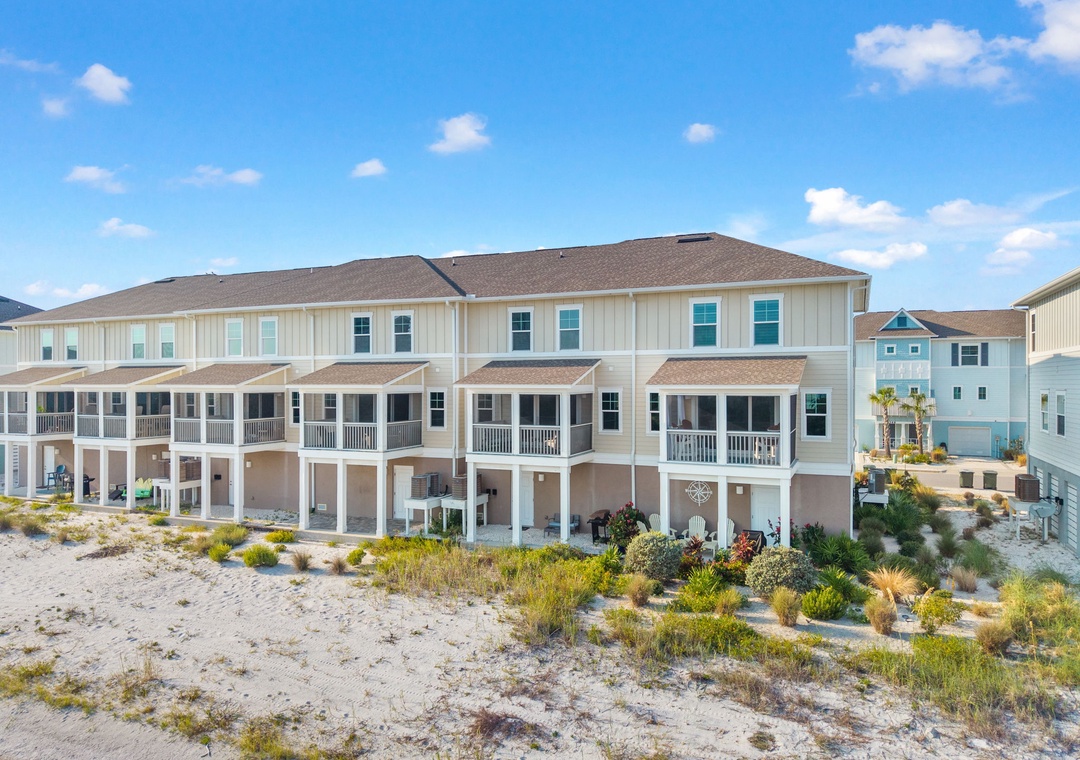 Saltwater & Sunsets- This coastal community features elevated beach townhomes with covered parking and private balconies, positioned directly on sandy shores with neighboring properties creating a welcoming seaside neighborhood.