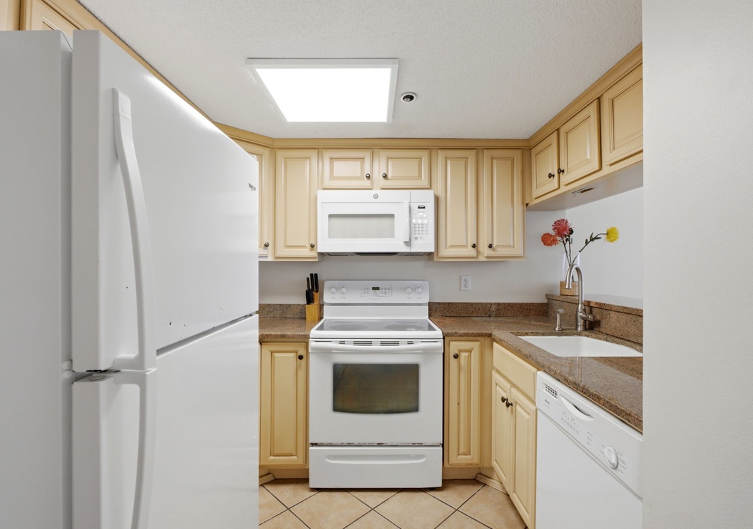Ocean Breeze E702- Your fully equipped kitchen features modern appliances, warm cabinetry, and a bright skylight—everything you need to prepare meals in comfort during your stay.