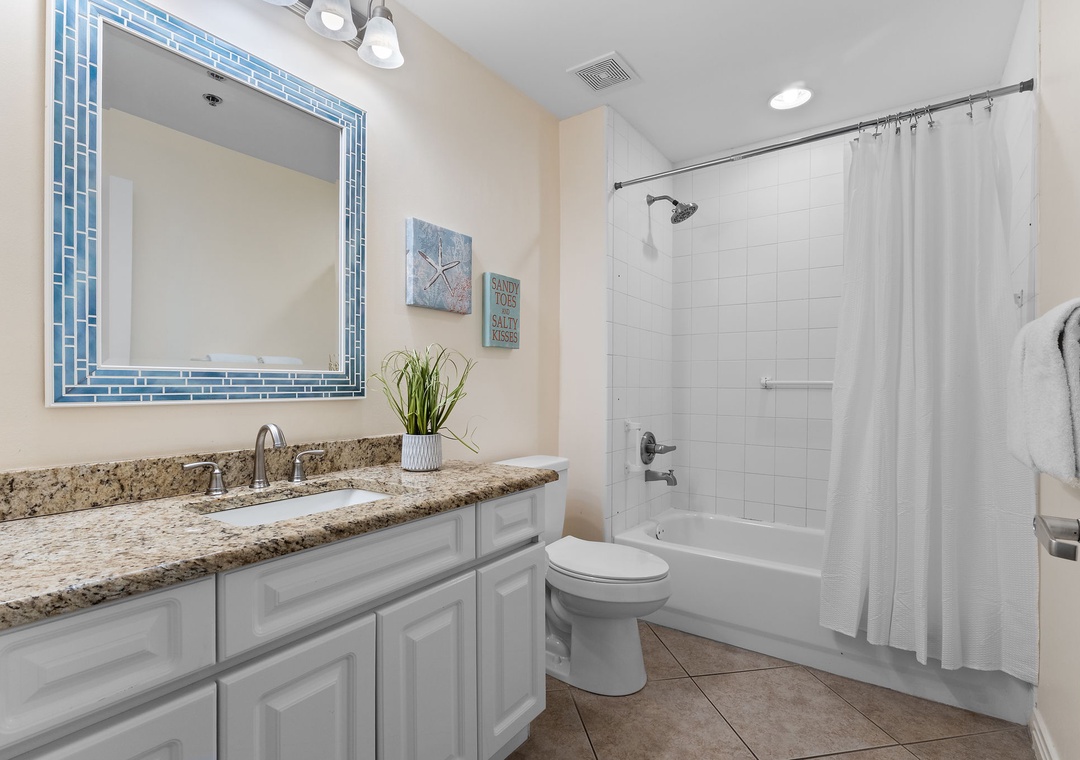 Beach Colony Tower 10C- Step into your private retreat with gleaming granite counters, a soothing tub-shower combo, and crisp white linens awaiting your arrival.