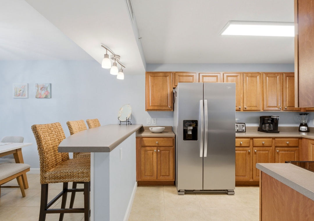 Sandy Key 637- Gather with loved ones in your fully equipped kitchen featuring stainless steel appliances, warm wood cabinetry, and an inviting breakfast bar perfect for casual meals.