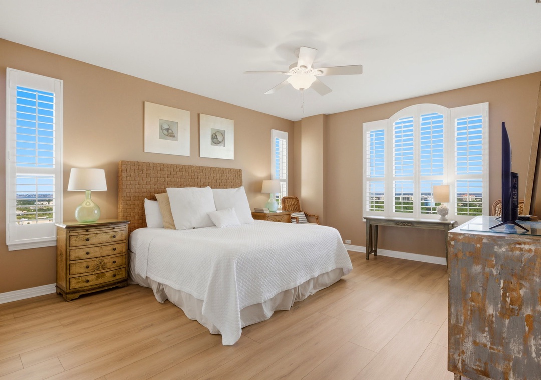 Beach Colony T PH1D-Wake up to serene views framed by shuttered windows that fill your room with natural light. The coastal-inspired bedroom invites you to unwind on plush bedding while the ceiling fan keeps you comfortable.