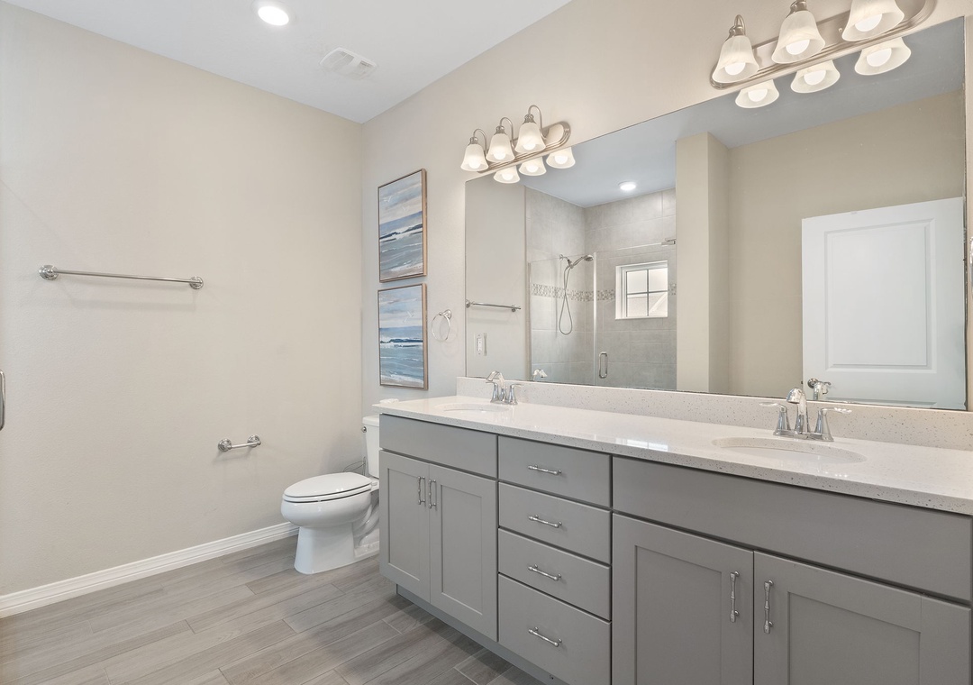 Saltwater & Sunsets- Step into your private bathroom with dual vanities, plenty of storage, and a spacious walk-in shower—a bright, serene space designed for comfort.