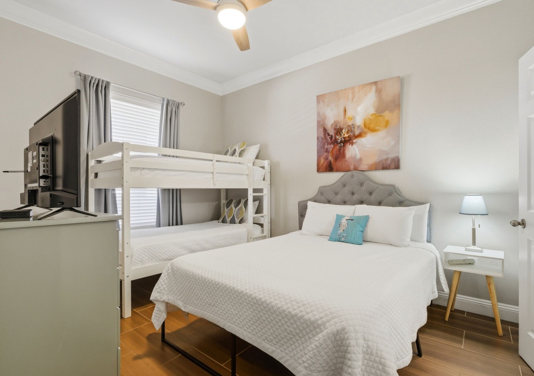 Your bright, serene bedroom welcomes you with a plush queen bed and cozy bunk beds—perfect for families or groups seeking comfort and flexibility in one inviting space.