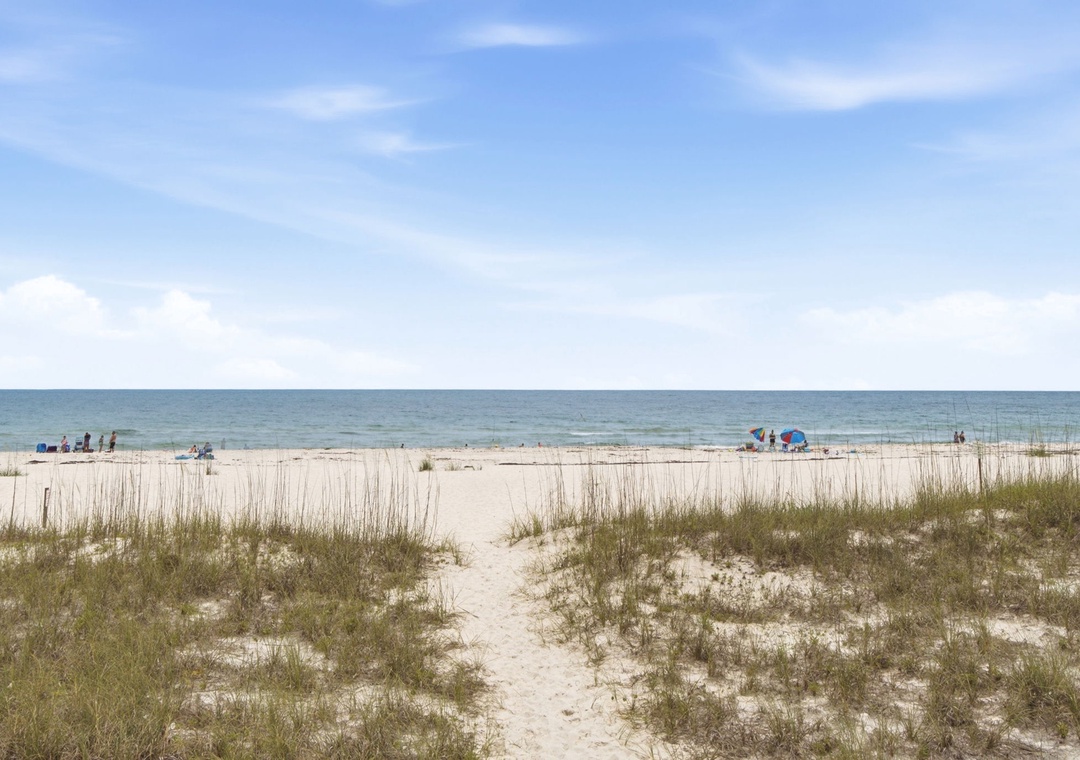 A sandy path leads through gentle dunes to a pristine white beach along the Gulf Coast, where the turquoise waters meet soft sands—just moments from the property.