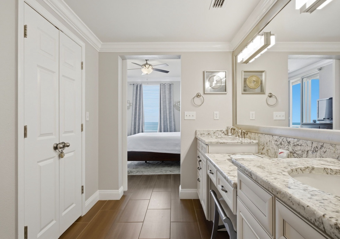 Step into your elegant ensuite, where polished marble counters and dual vanities create a serene retreat connecting to your peaceful bedroom beyond.