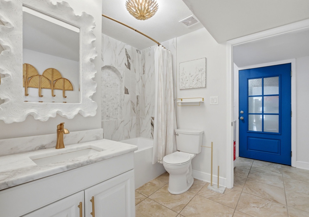 North Lost Key Landing B2- Freshen up in your stylish bathroom featuring elegant marble finishes, gold accents, and modern fixtures. The shower awaits after your day of exploring.