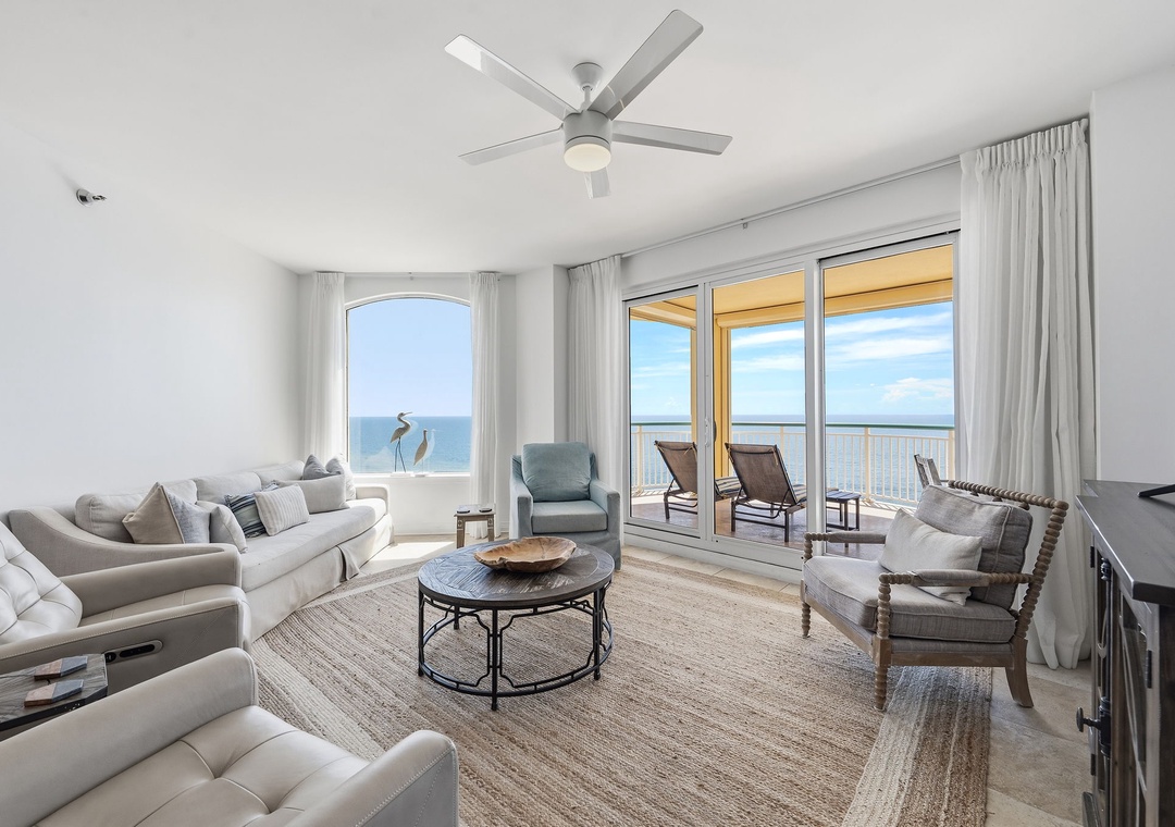 Beach Colony T14B- Sink into plush seating with breathtaking ocean views stretching across the horizon. Cool breezes flow through your private balcony, where sun-soaked loungers await your peaceful escape.