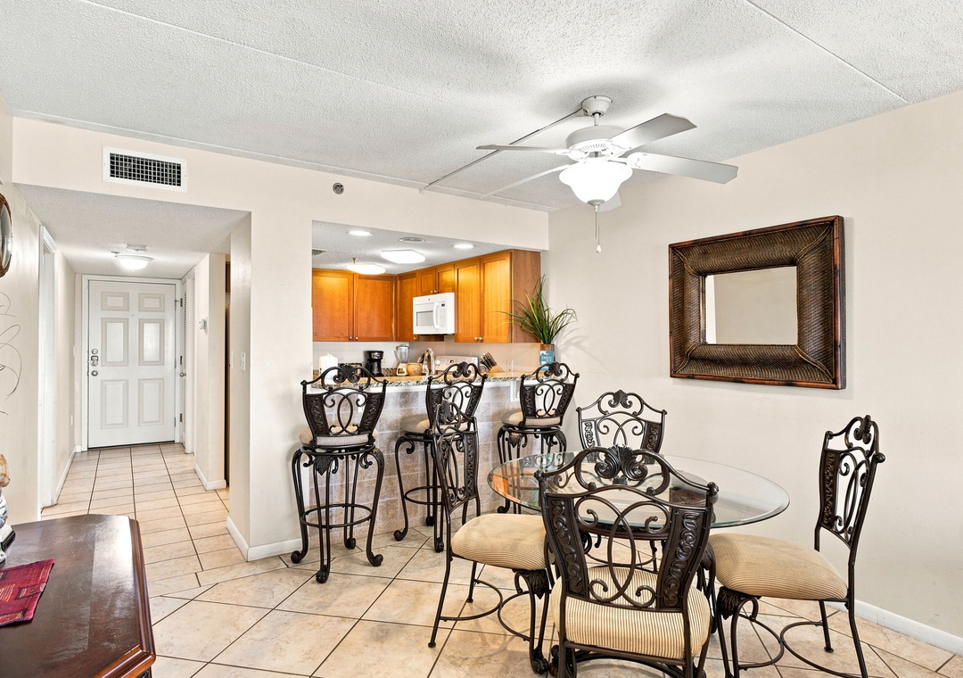 Ocean Breeze W 105- Your open dining and kitchen area invites relaxed meals under a gentle ceiling fan, with warm wood cabinetry and a welcoming counter bar just steps away.