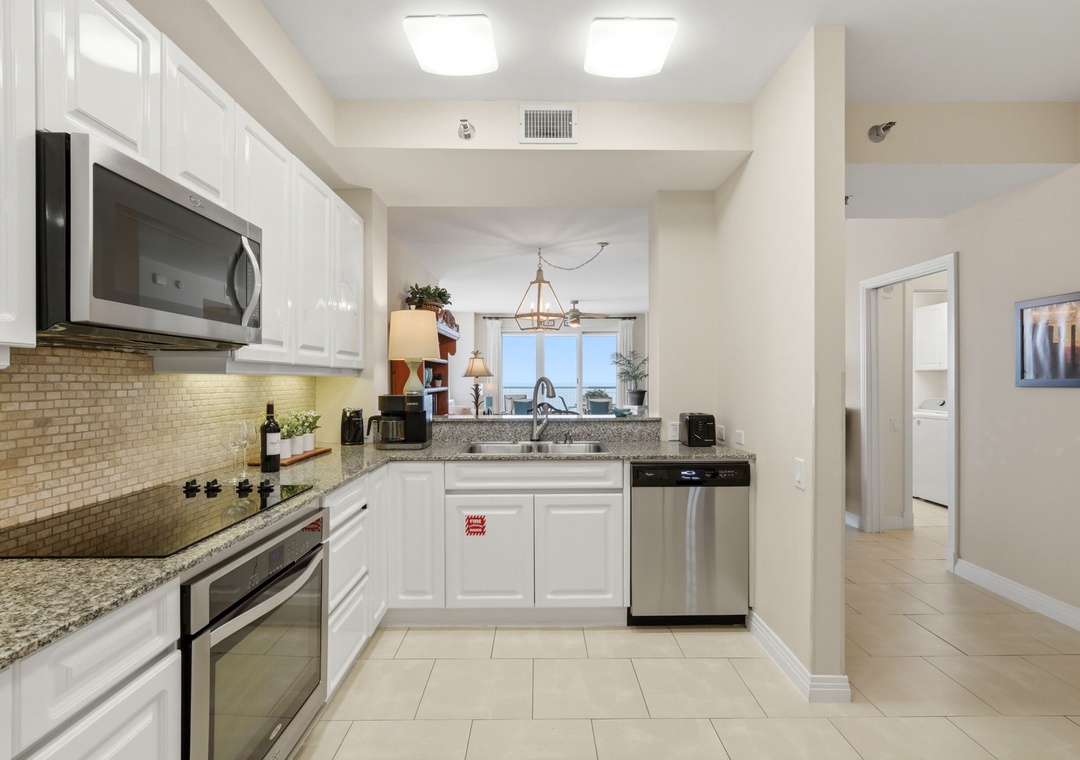 Beach Colony Tower PH1B - Your fully equipped kitchen features granite counters, stainless appliances, and stylish backsplash—perfect for preparing home-cooked meals during your stay.