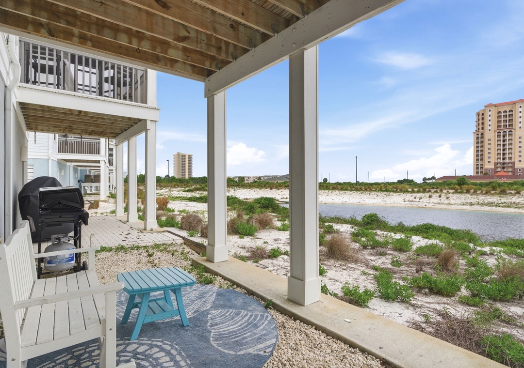 The property's elevated location near water and coastal greenery, with neighboring buildings visible in the distance.