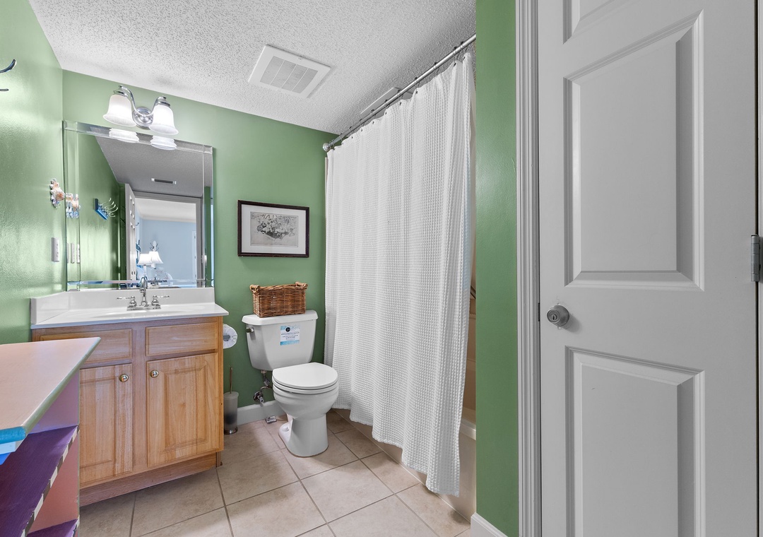 Sandy Key 338- Step into your private bathroom retreat, where refreshing green walls and crisp white linens create a bright, invigorating space. The full-sized tub and shower combo invite you to unwind after your day of adventure.