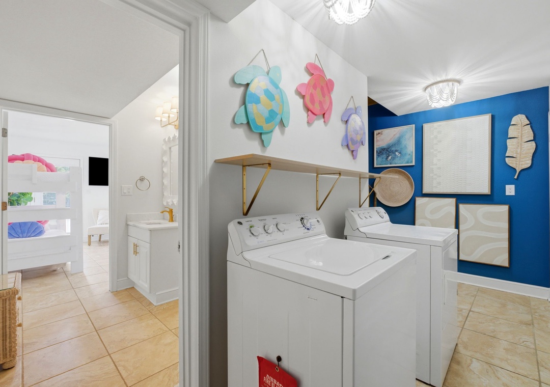 North Lost Key Landing B2- Your in-unit laundry room features a full-size washer and dryer beneath cheerful coastal-themed turtle art, making it easy to keep your beachwear fresh throughout your stay.