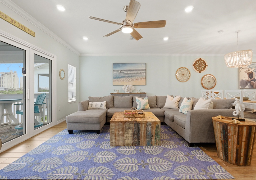 Unwind in your coastal living room with comfortable sectional seating, beach-inspired decor, and a ceiling fan keeping you cool as you enjoy the ocean breeze.