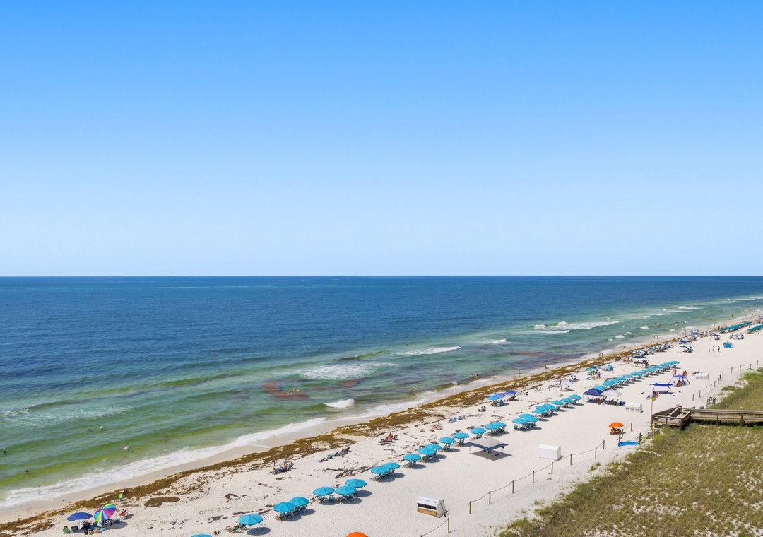 A pristine beachfront location with white sand shoreline and Gulf waters, featuring convenient beach amenities and natural coastal dunes near the property.