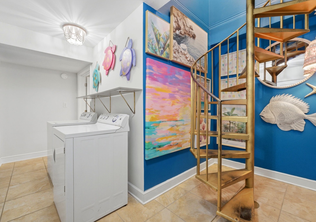North Lost Key Landing B2- Your home away from home includes a convenient laundry area and a charming spiral staircase to an upstairs loft, all adorned with cheerful coastal artwork.