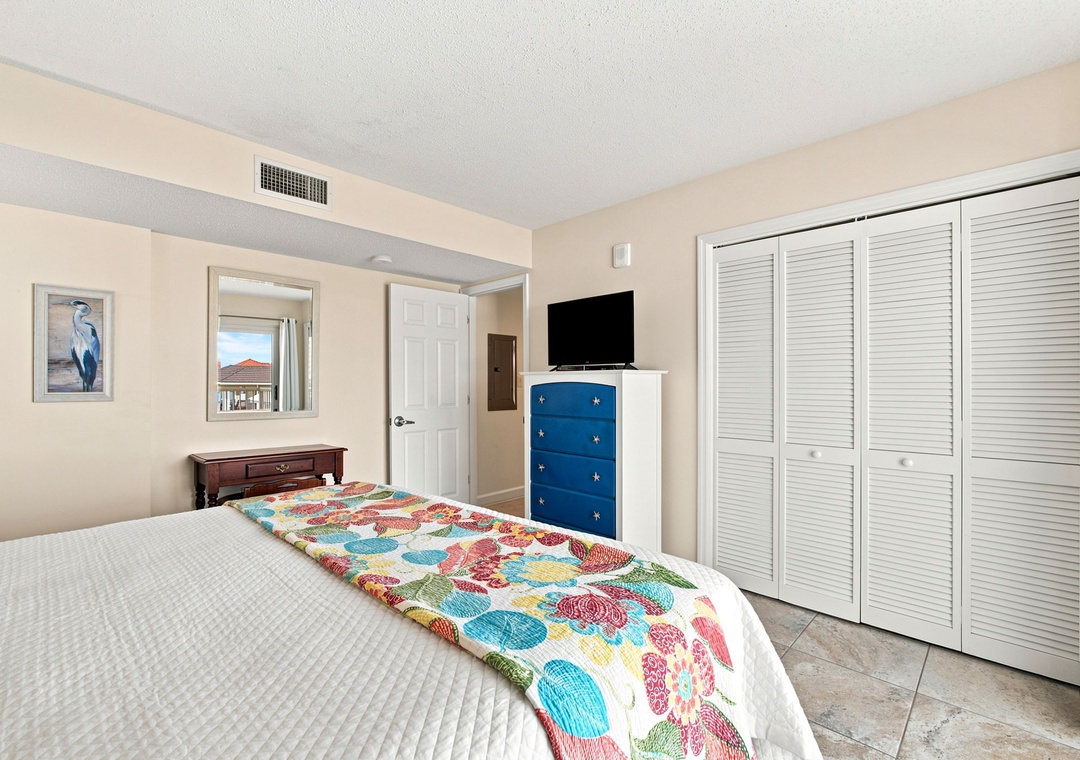 Sandy Key 411- Your bright, coastal bedroom features a comfortable bed dressed in cheerful linens and plenty of storage in the spacious louvered closet. Relax and unwind while enjoying your favorite shows on the flat-screen TV.