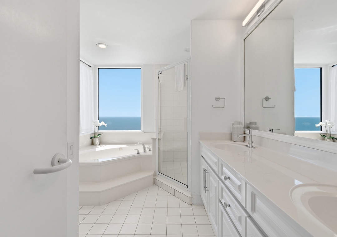 Beach Colony T14B- Soak in a spa-like sanctuary with a deep soaking tub, walk-in shower, and breathtaking ocean views that stretch across the horizon from your bathroom's private window.