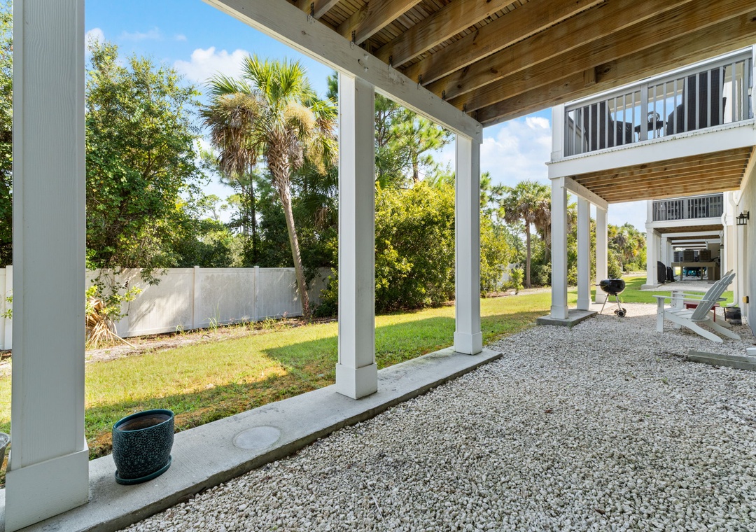 Turtles Nest- The property features a covered outdoor area beneath the raised structure, surrounded by lush tropical palms and greenery in a peaceful setting.