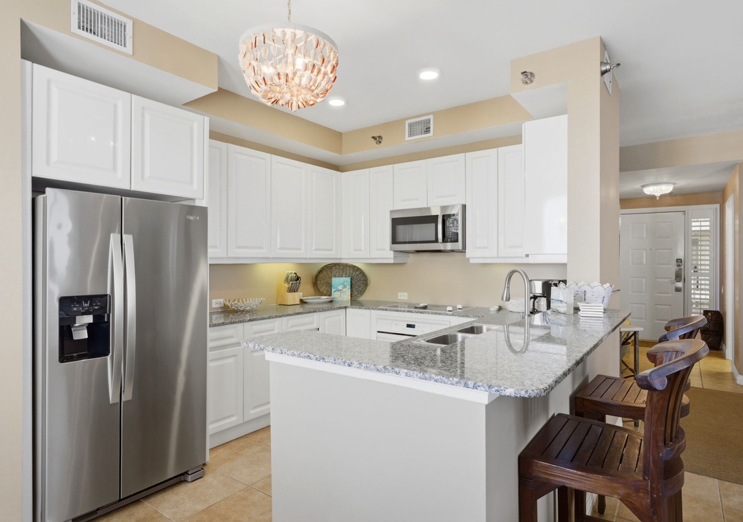 Beach Colony T PH1D- Your fully equipped kitchen features modern stainless appliances, granite counters, and a breakfast bar where you can gather for morning coffee or plan your day's adventures together.