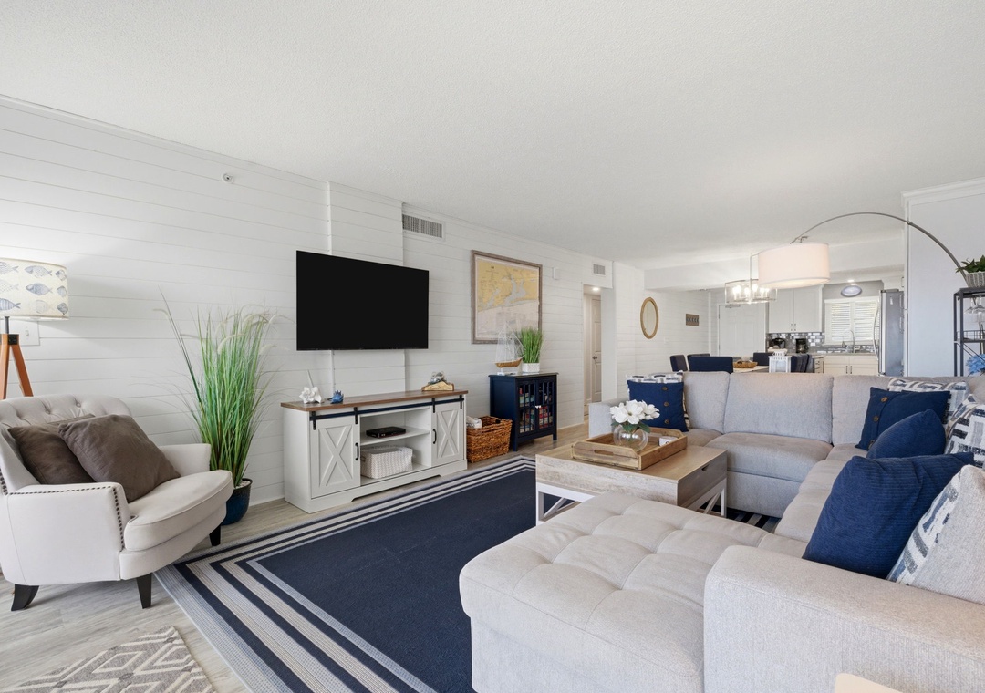 Settle into this inviting living space with plush seating, coastal decor, and modern entertainment. Your home away from home opens to a fully-equipped kitchen, ready for your stay.